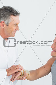 Male doctor examining a patients hand in the medical office