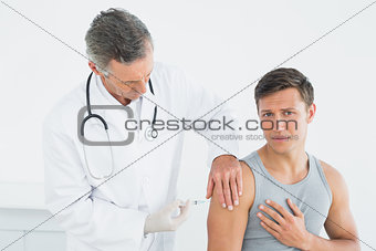 Male doctor injecting a patients arm