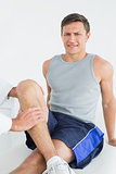 Portrait of a young man getting his leg examined
