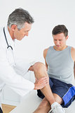 Displeased young man getting his leg examined