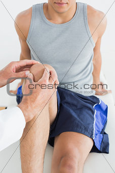 Close-up of a man getting his knee examined