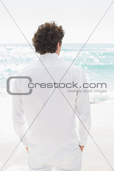 Handsome groom looking out to sea