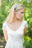 Content beautiful blonde bride with hands behind back
