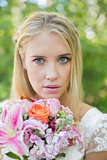 Blonde bride looking at camera holding bouquet