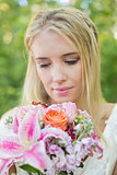 Happy bride looking at her bouquet