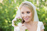 Smiling bride holding her bouquet wearing a veil
