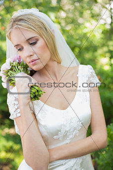 Content bride holding her bouquet wearing a veil