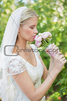 Peaceful bride smelling her bouquet