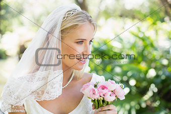 Happy bride in a veil holding her bouquet