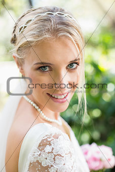 Blonde bride in a veil smiling to camera