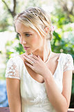 Content blonde bride with hand on chest