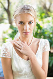 Content blonde bride with hand on chest looking at camera
