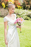 Pretty blonde bride holding lily bouquet