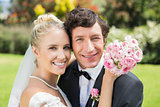 Attractive bride and groom hugging and smiling at camera