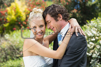 Husband hugging his new wife smiling at camera