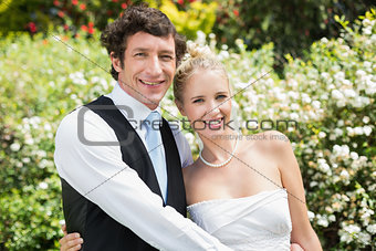 Romantic happy newlywed couple smiling at camera
