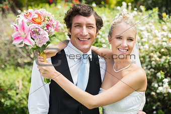Romantic newlywed couple smiling at camera on their wedding day