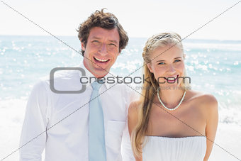 Romantic couple smiling at camera on their wedding day