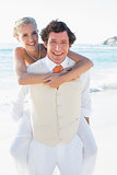Happy bride getting a piggy back from husband