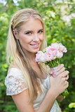 Blonde bride holding pink bouquet smiling at camera