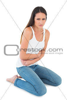 Displeased casual young woman with stomach pain