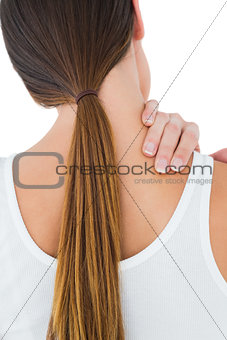 Rear view of a casual woman suffering from neck ache