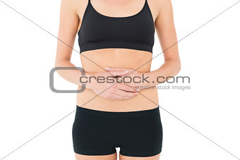 Mid section of a fit young woman with stomach pain