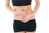 Mid section of a fit young woman with stomach pain