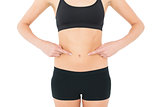 Close-up mid section of a fit woman with hands on stomach