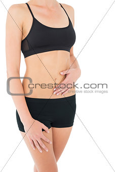 Close-up mid section of a fit woman in black sportswear