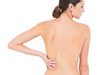 Rear view of a fit topless woman with back pain