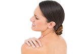 Close-up of a topless young woman with shoulder pain