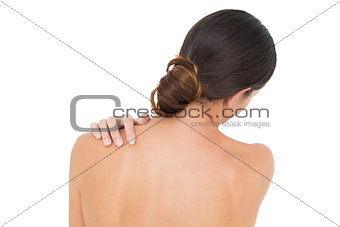 Close-up of a topless woman with shoulder pain