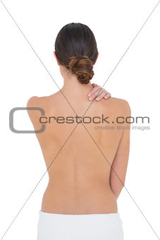 Rear view of a topless fit woman with shoulder pain