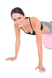 Fit young woman doing push ups on fitness ball