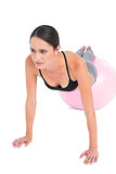 Full length of a fit woman doing push ups on fitness ball