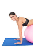 Side view portrait of a woman stretching on fitness ball