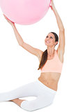 Smiling fit woman sitting with fitness ball