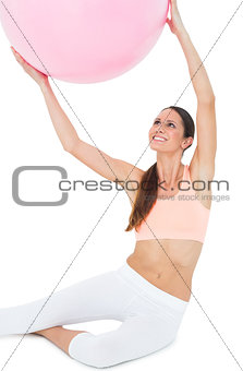 Smiling fit woman sitting with fitness ball