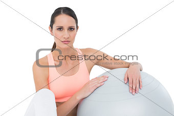 Portrait of a fit woman sitting with fitness ball