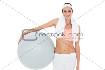 Portrait of a smiling fit woman holding fitness ball