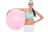 Portrait of a smiling fit woman holding fitness ball