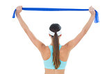 Rear view of a fit woman holding up a yoga belt