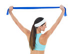 Fit young woman holding up a blue yoga belt
