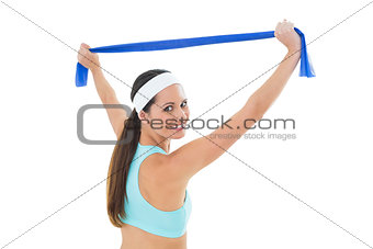 Fit young woman holding up a blue yoga belt
