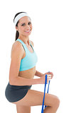 Portrait of a fit woman exercising with a blue yoga belt