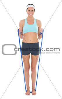 Smiling fit young exercising with a blue yoga belt