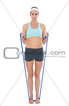 Fit woman exercising with a blue yoga belt