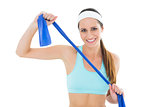 Smiling fit young woman holding blue yoga belt