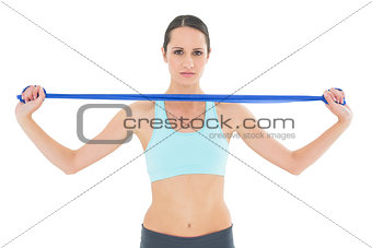 Serious fit young woman holding blue yoga belt
